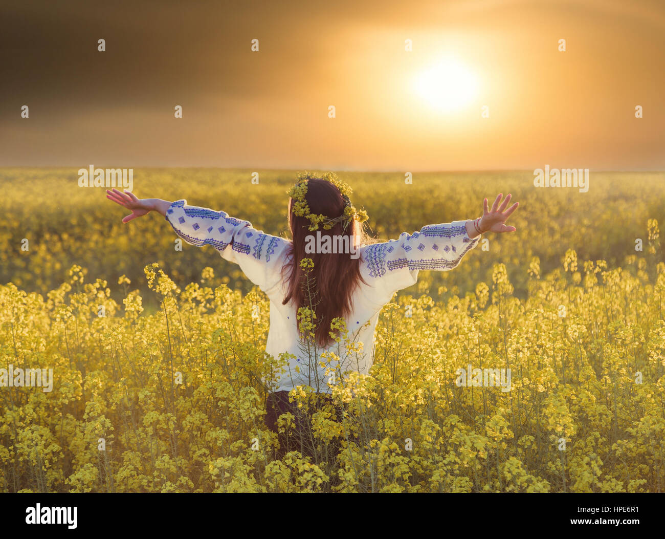 Portrait of a young woman in a rapeseed field. Young girl wearing ...