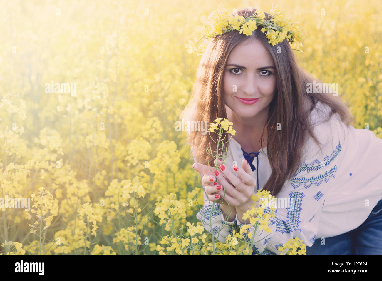 Portrait of a young woman in a rapeseed field. Young girl wearing ...