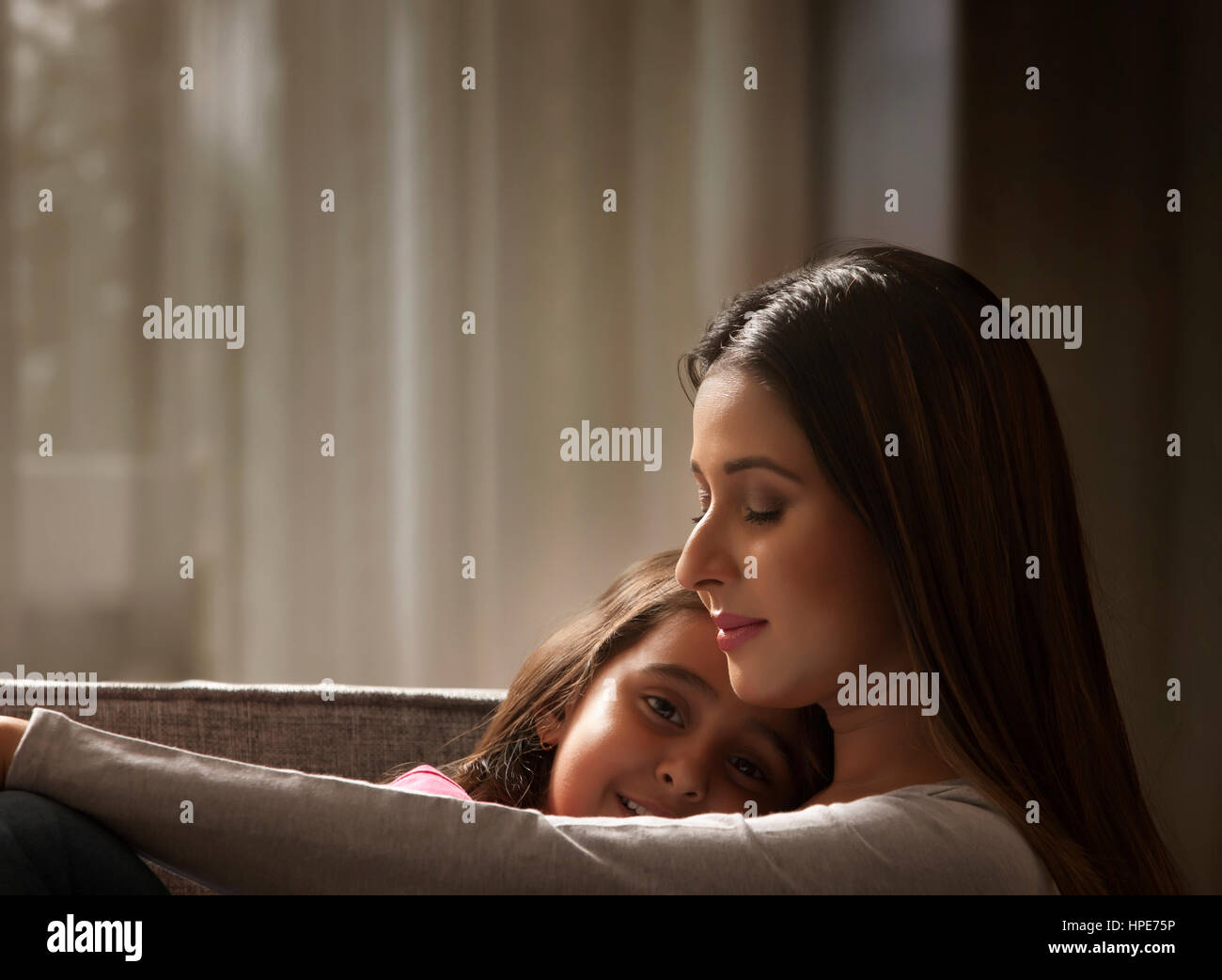 Close-up of Little girl and mother cuddling Stock Photo