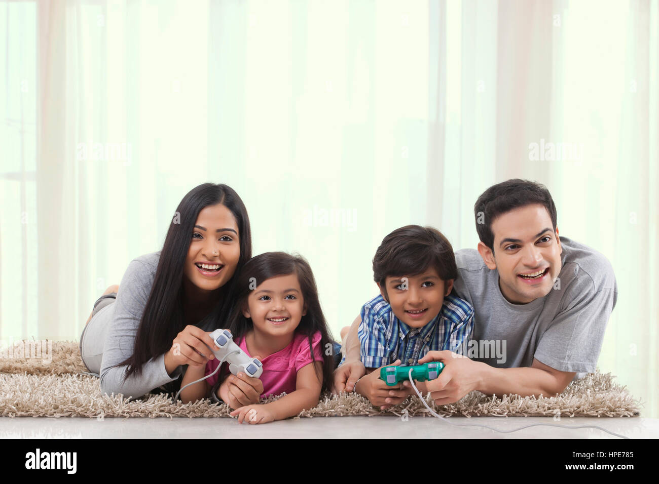 Family playing game with game console in living room Stock Photo