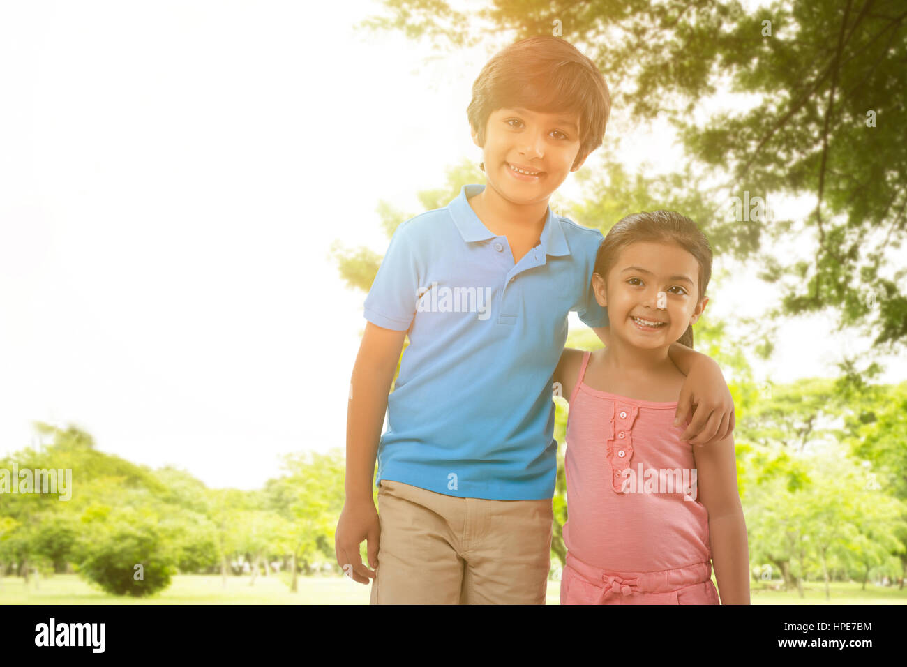 Portrait of brother and sister in park Stock Photo - Alamy
