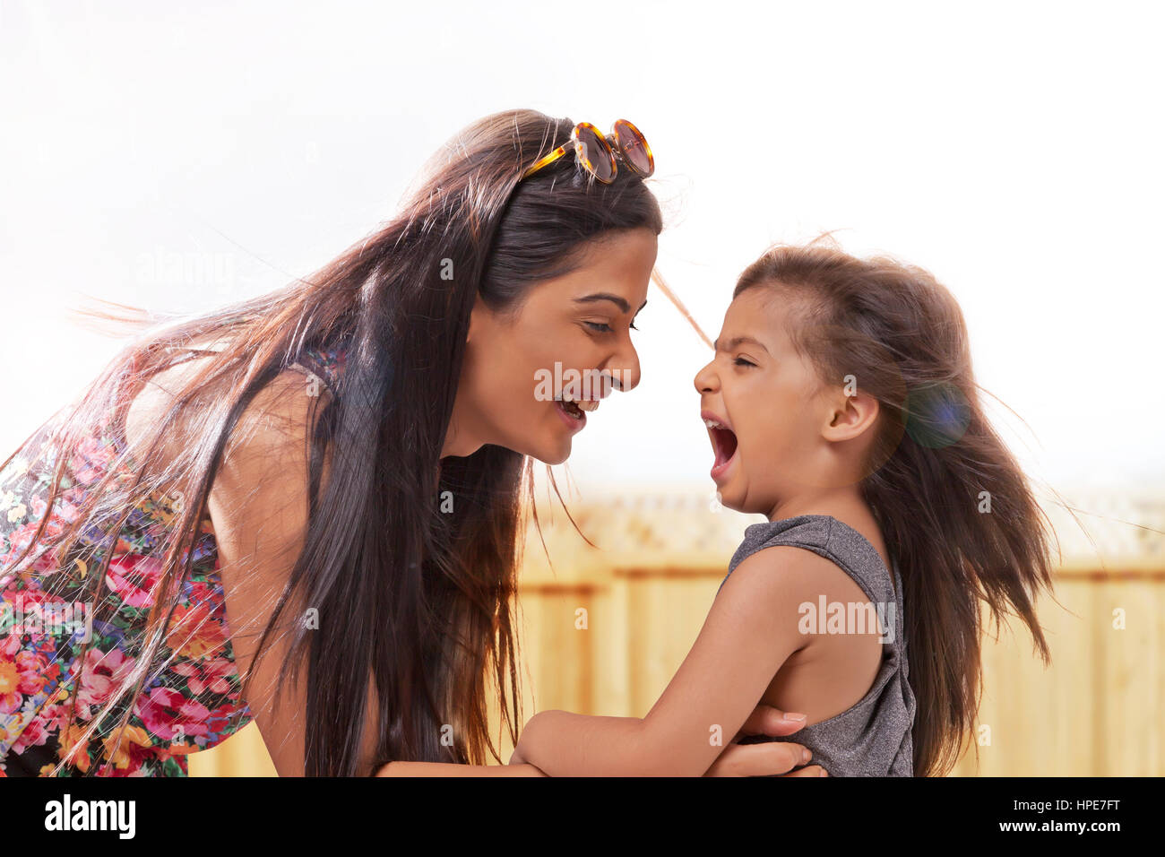 Portrait of mother and daughter smiling face to face Stock Photo