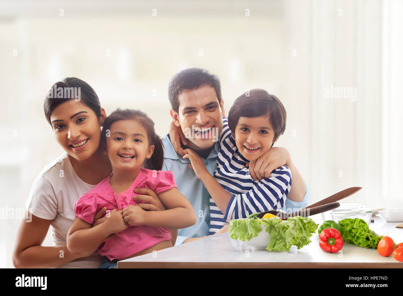 Happy family sitting together at kitchen table Stock Photo