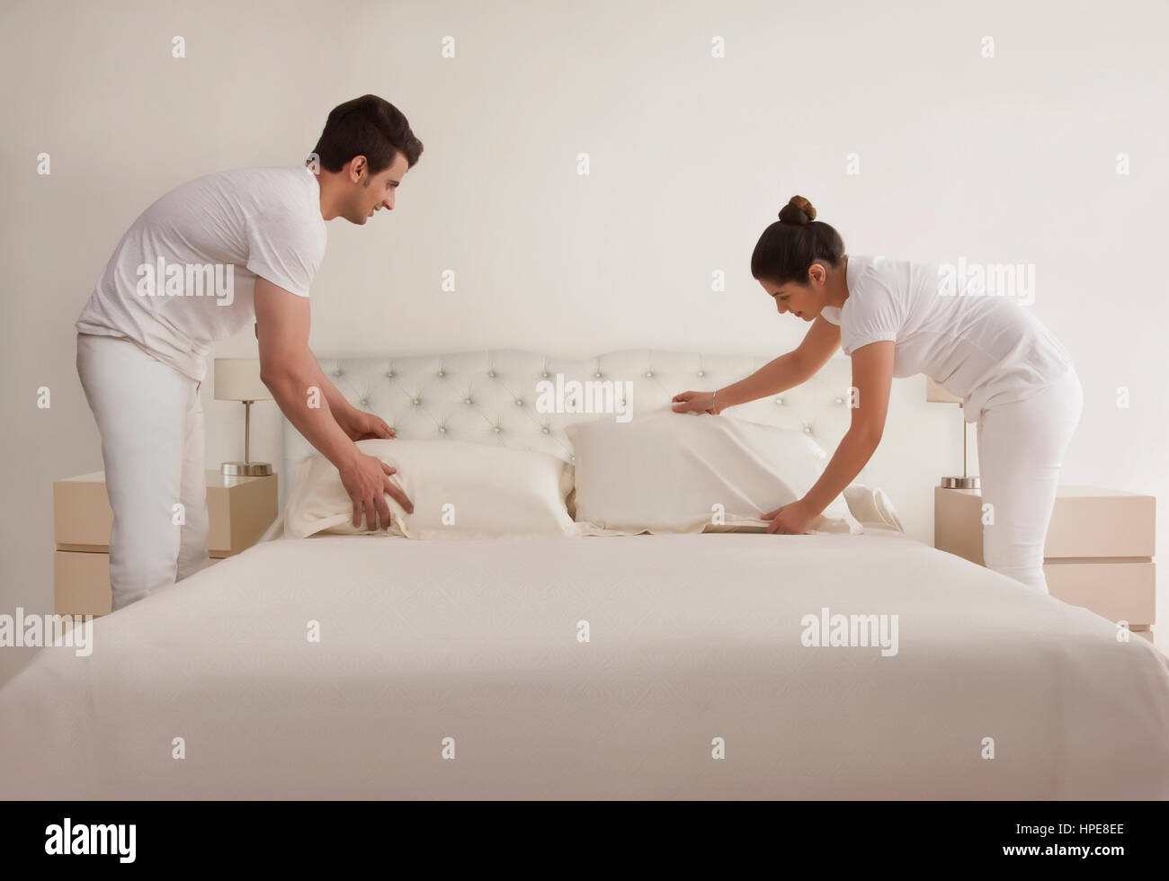 Young couple making bed Stock Photo