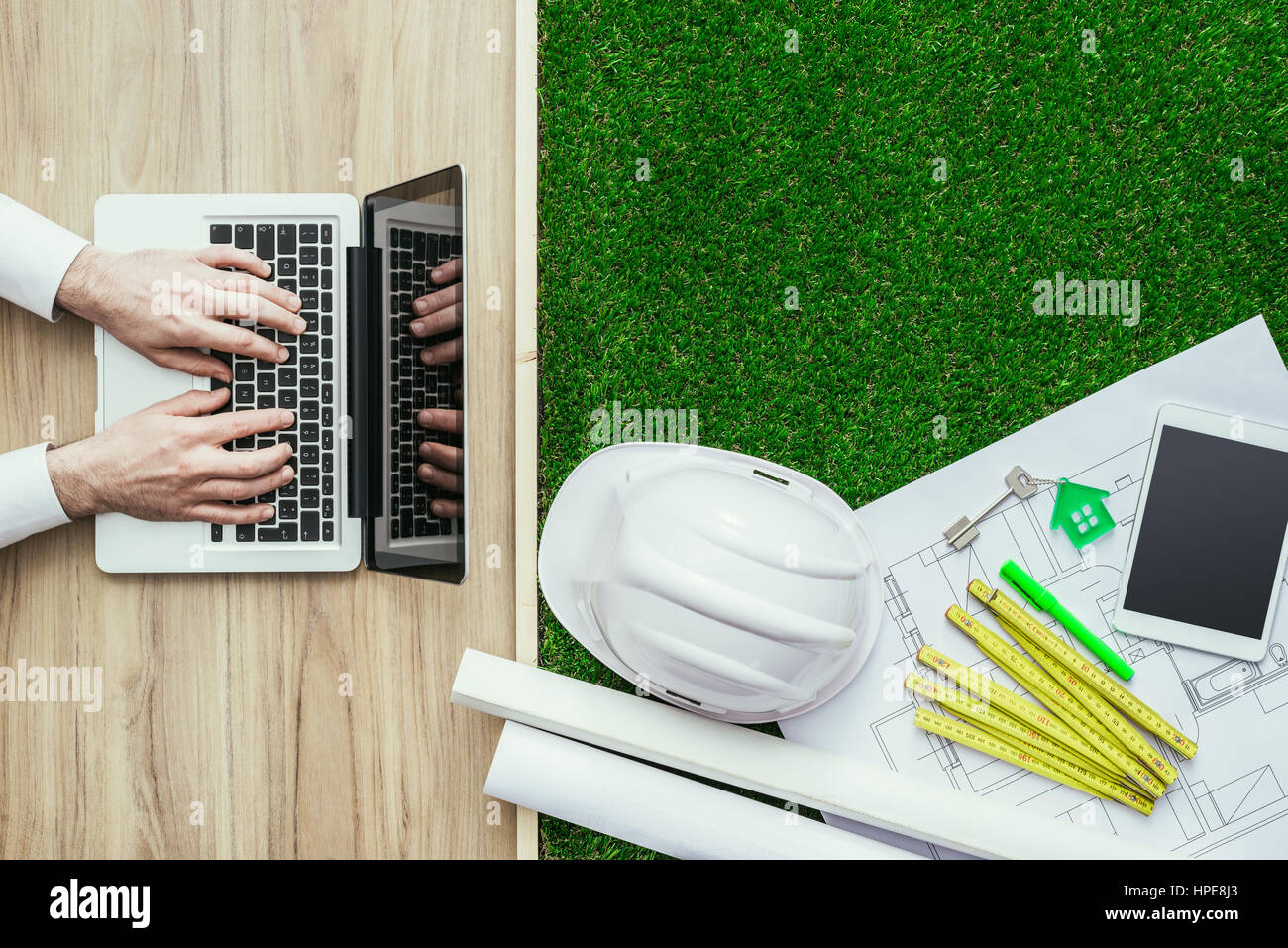 Engineer designing a green sustainable house and using a laptop ...