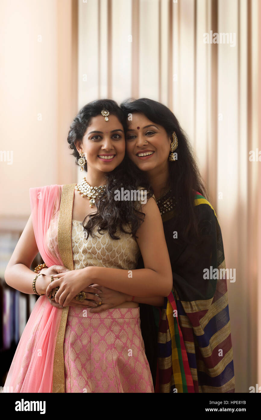 Mother and daughter embracing in traditional clothing Stock Photo