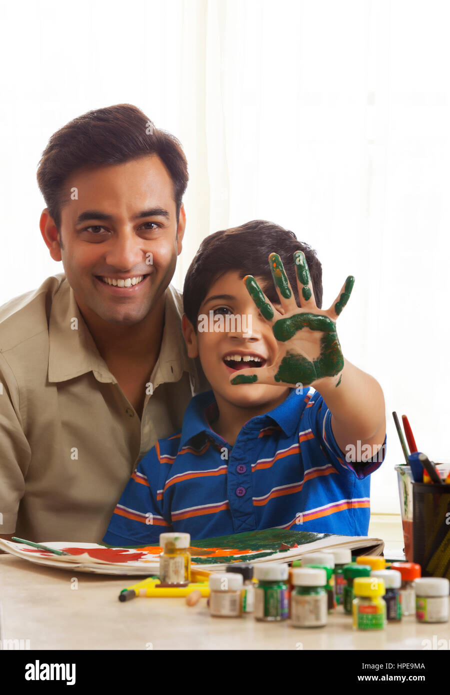 Father and son finger painting together Stock Photo