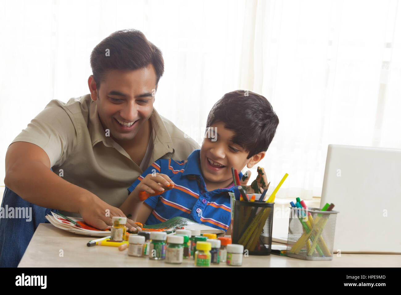 Father and son finger painting together Stock Photo