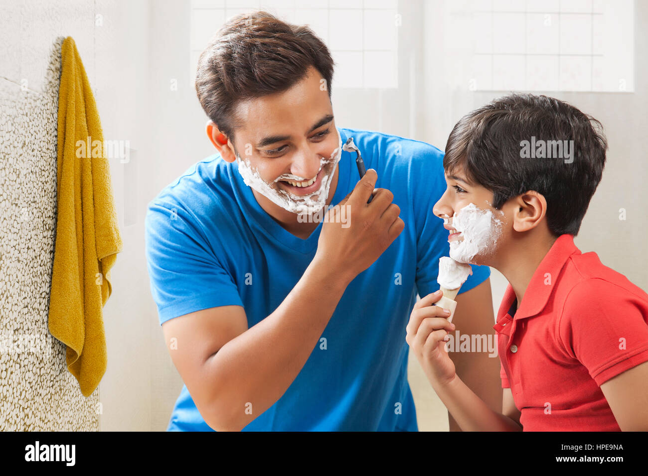 Boy applying shaving cream with father Stock Photo