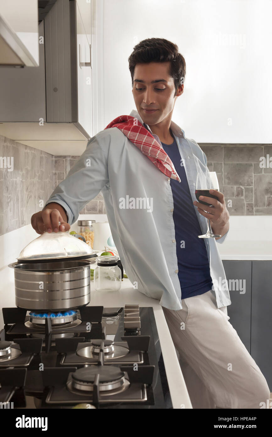 Young man cooking food in kitchen Stock Photo - Alamy