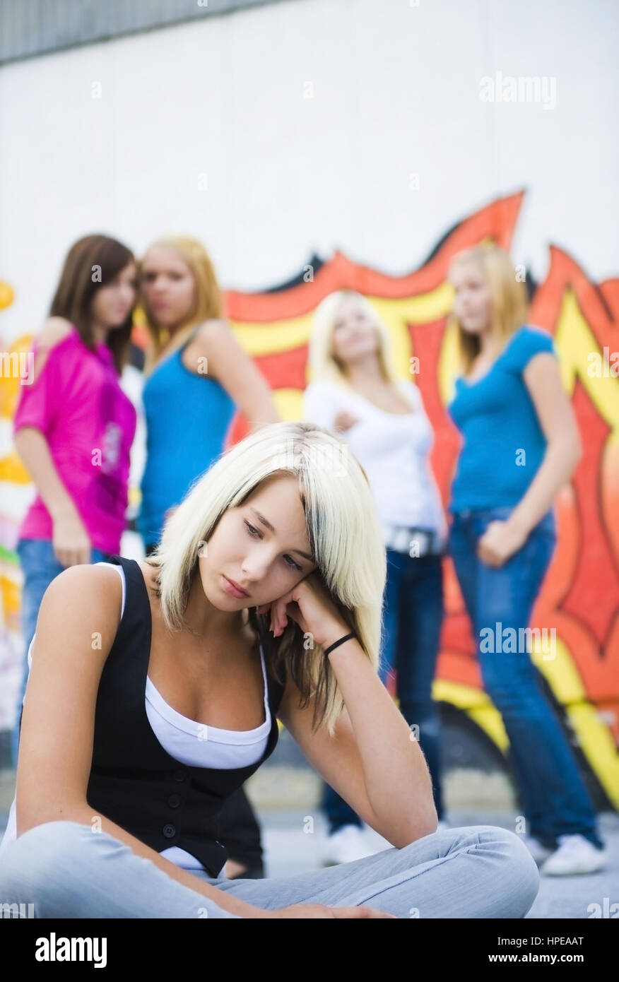 Model released , Jugendliches Maedchen wird von Gleichaltrigen gemobbt - teenager mobbing Stock Photo