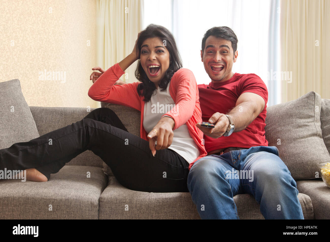 Excited young couple watching TV Stock Photo
