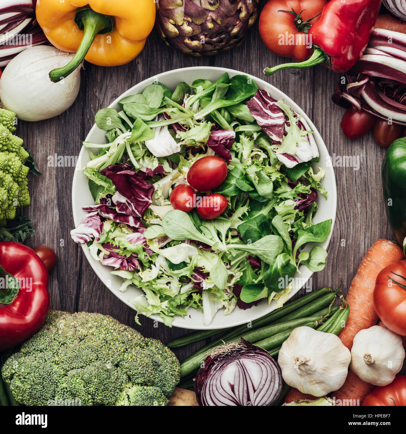 Fresh tasty vegetarian salad with seasonal ingredients surrounded by colorful vegetables, healthy vegetarian eating concept Stock Photo
