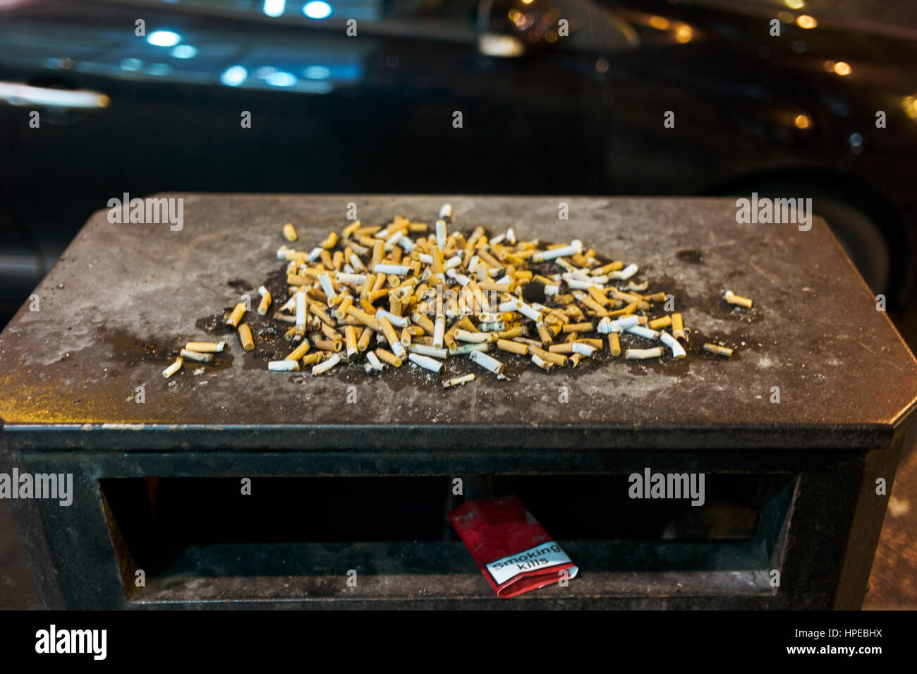Cigarette ends on bin in Glasgow at night Stock Photo