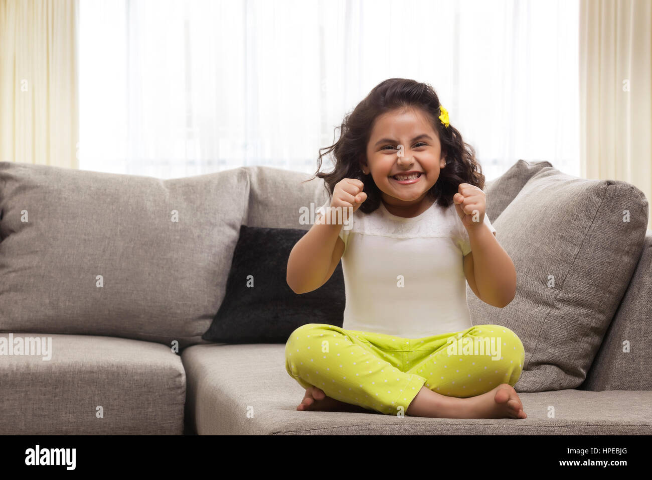 Cheerful young girl holding her fists up Stock Photo