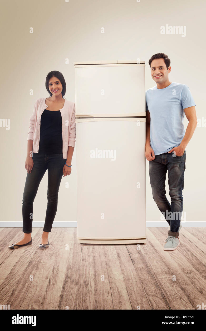 Young couple leaning on fridge Stock Photo