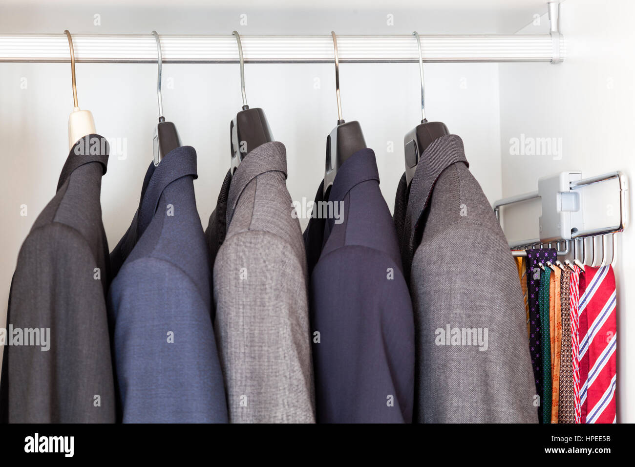 Man suits and ties inside a wardrobe Stock Photo