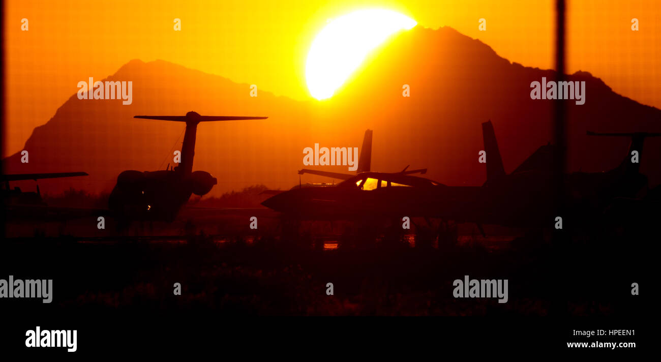 Bright sun and intense orange and gold color. You can see an impressive solar circle at sunset with the planes at the airport Stock Photo