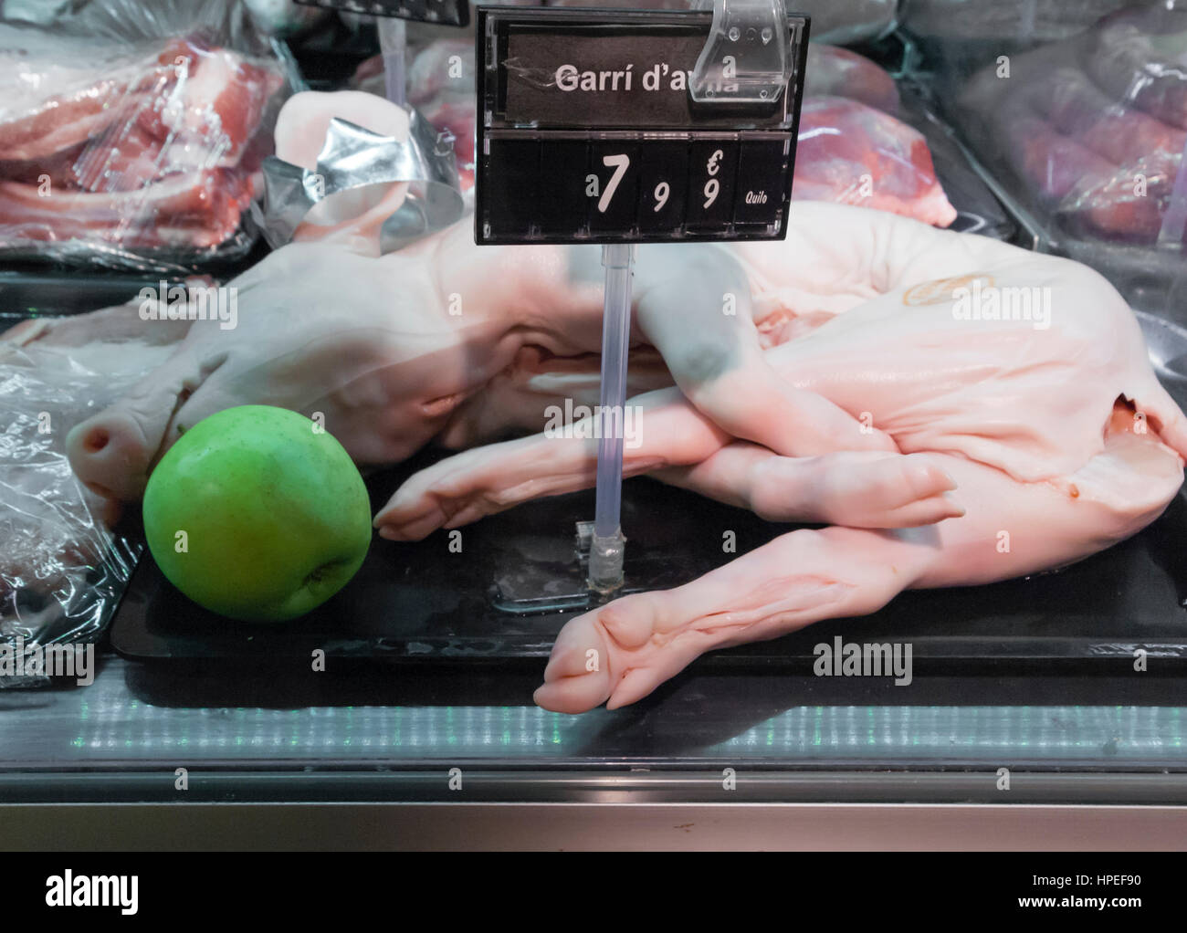 A whole piglet displayed for sale in a refrigerator in a supermarket in Barcelona, Spain. Stock Photo