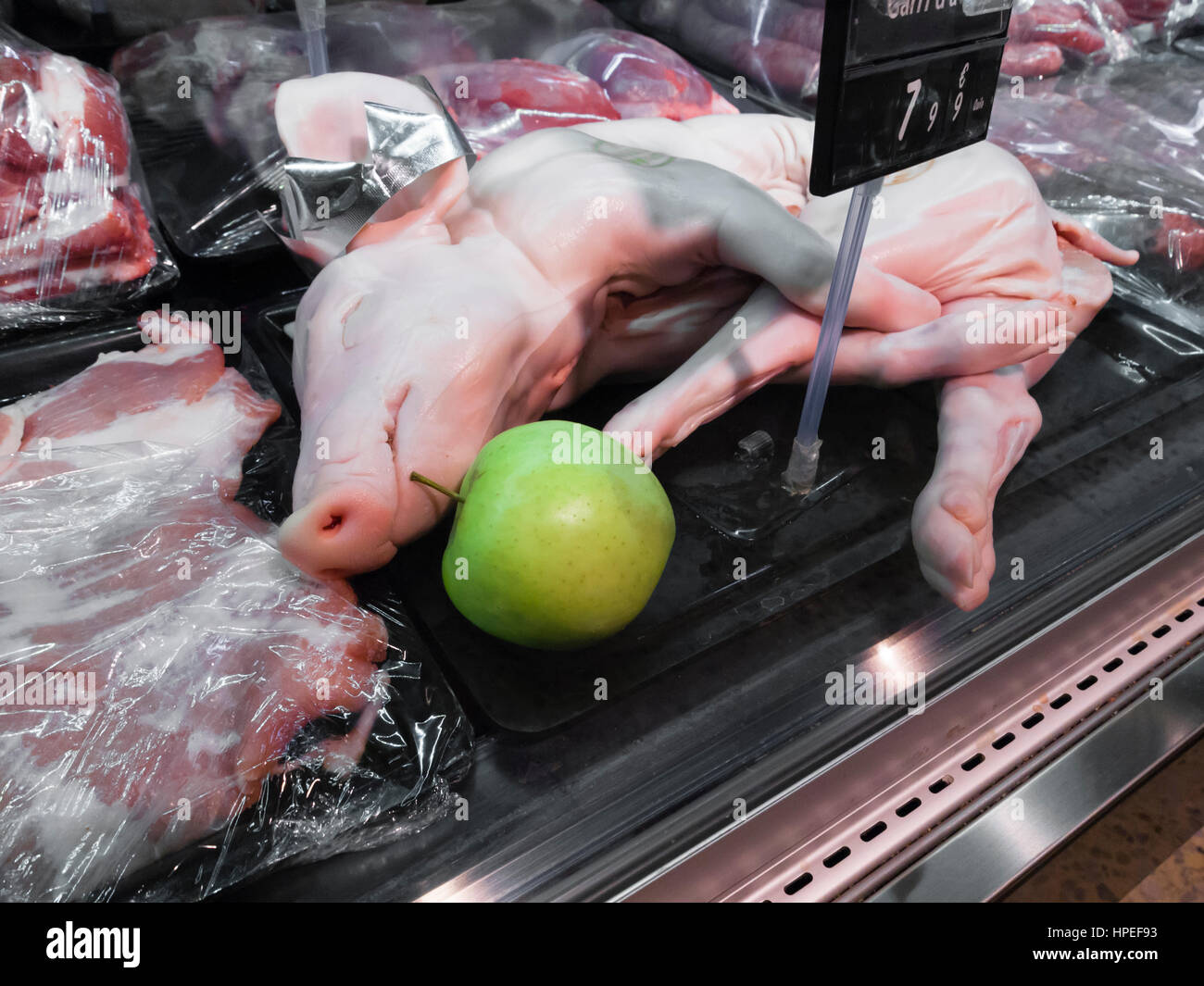 A whole piglet is displayed for sale in a refrigerator at a supermarket in Barcelona, Spain. Stock Photo