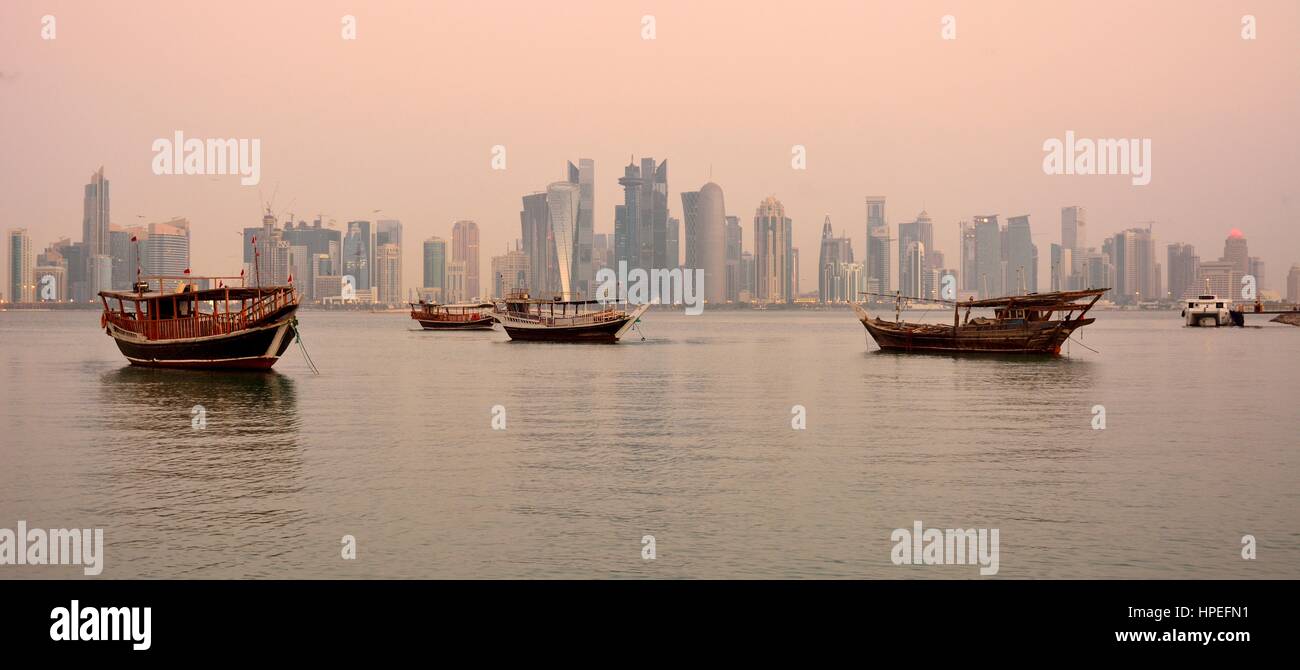 Doha, Qatar - November 2, 2016. View of Doha skyline in Qatar at dawn, with skyscrapers and dhow boats. Stock Photo