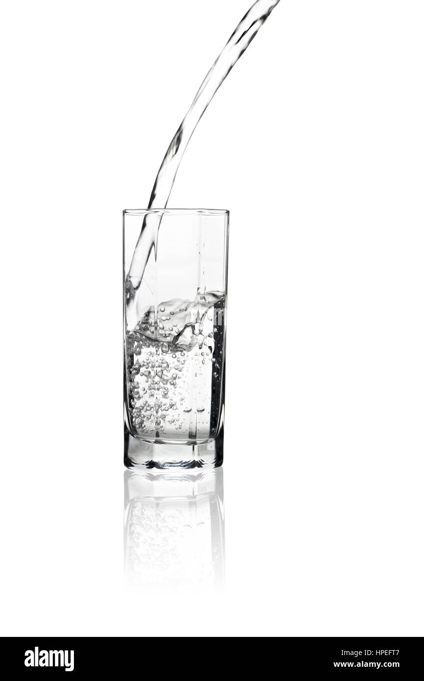 Water flowing into a tall glass with its reflection isolated on white