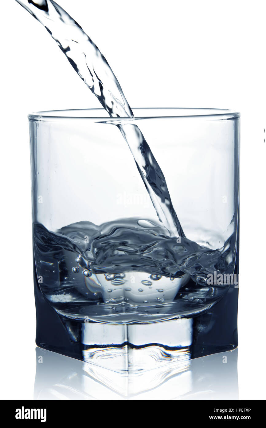 Blue water pouring into glass closeup view isolated on white