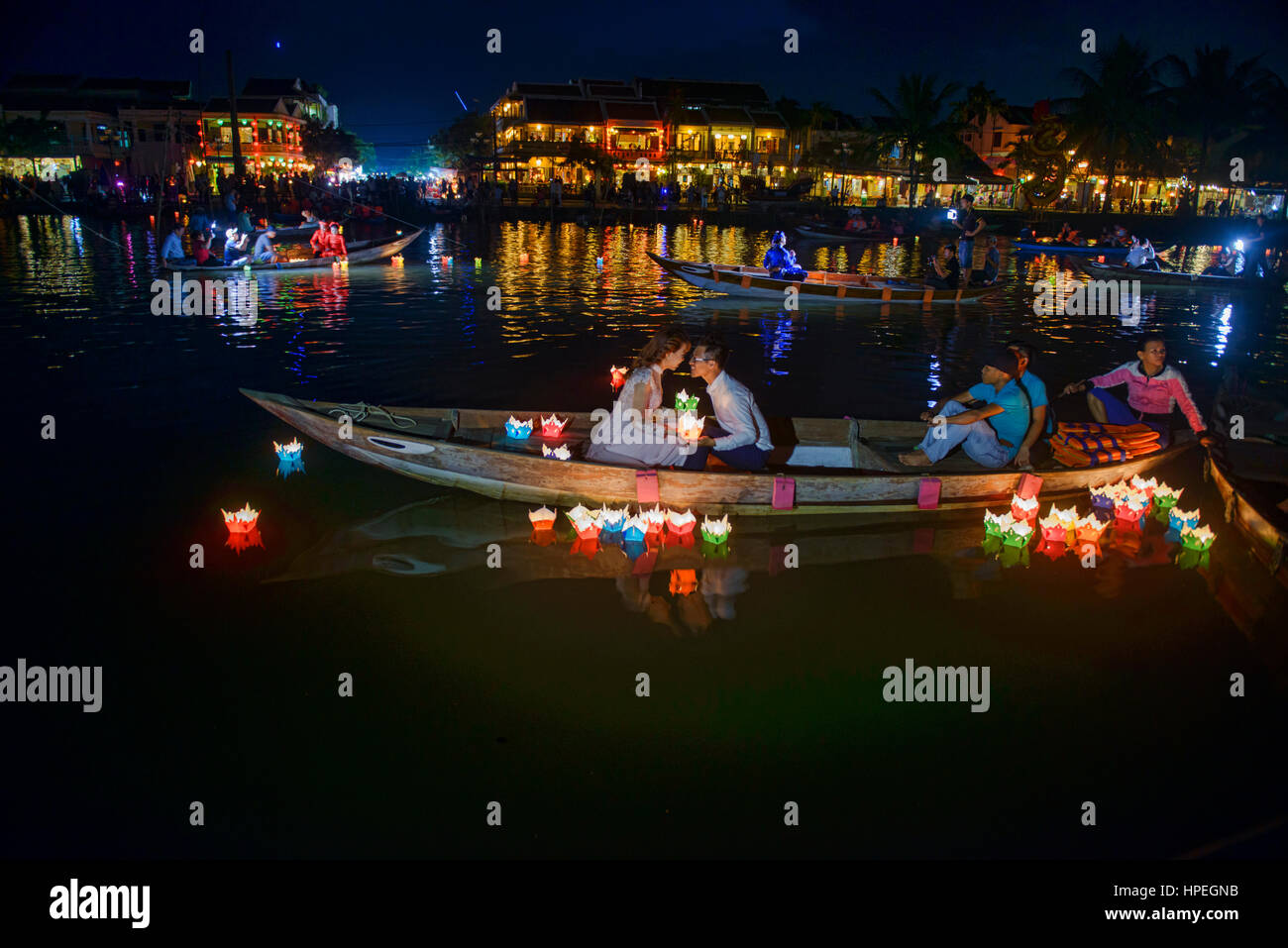 Couple floats candle lanterns on the Thu Bon River during the full moon
