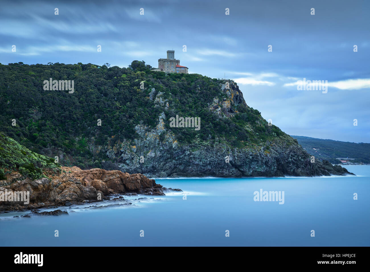 Cliff rock and building on the sea on winter. Quercianella, Tuscany riviera, Italy, Europe. Long Exposure Stock Photo