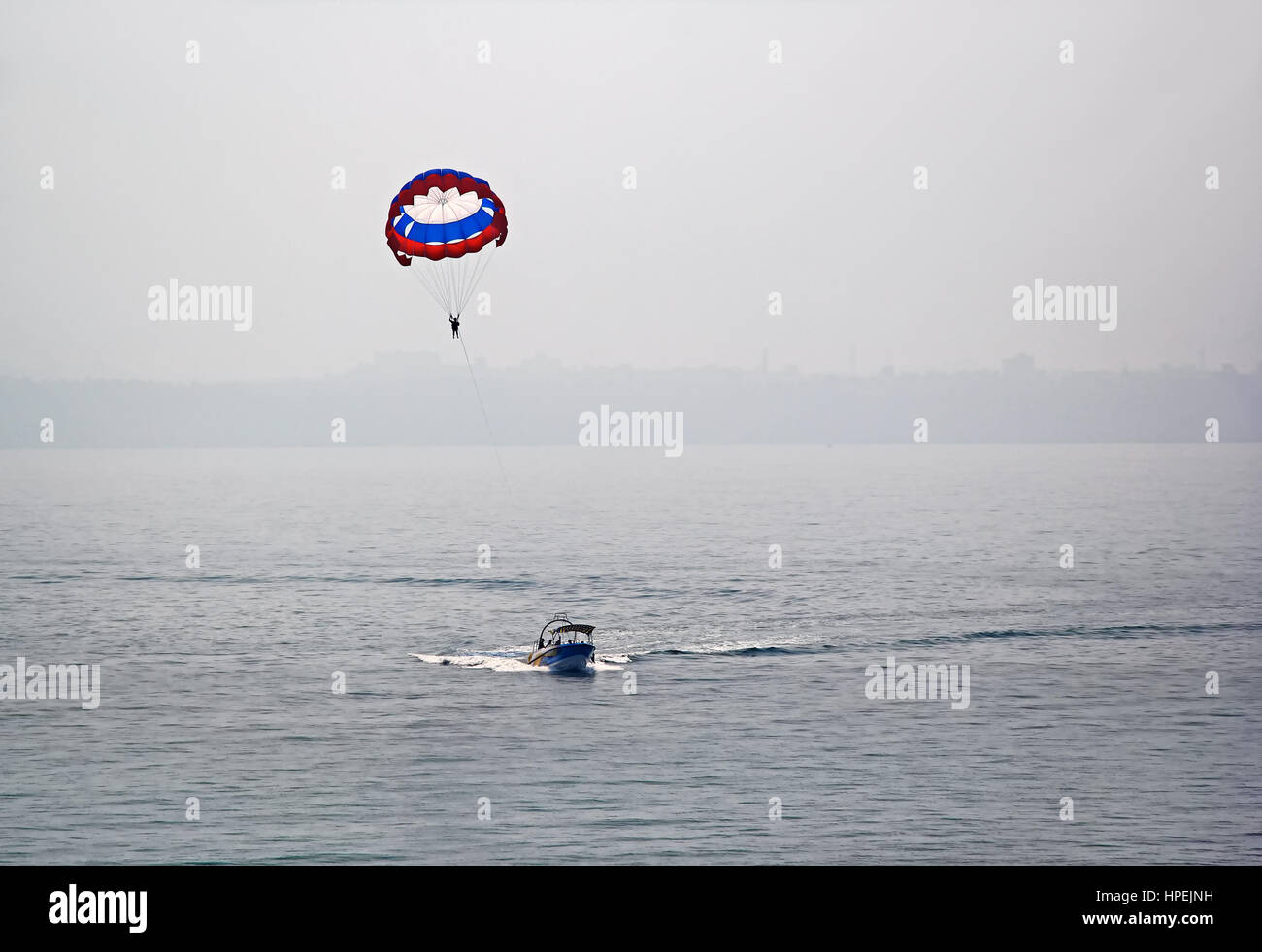 Offshore paragliding by hauling by speed boat at the sea around Dona Paula in Goa, India Stock Photo