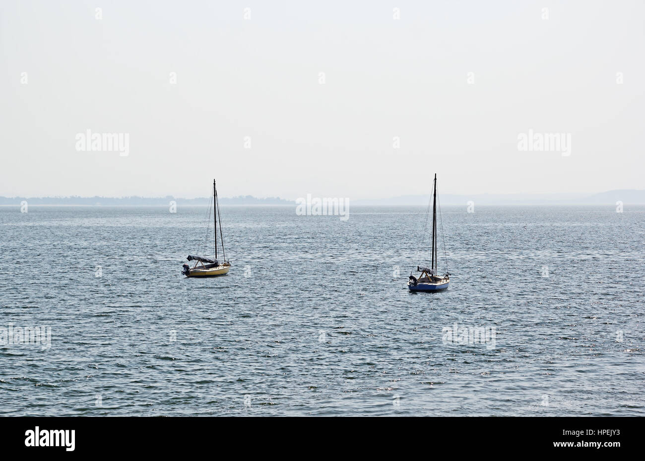 Serene morning scene of two sailboats anchored in outer sea in Dona Paula in Goa, India Stock Photo