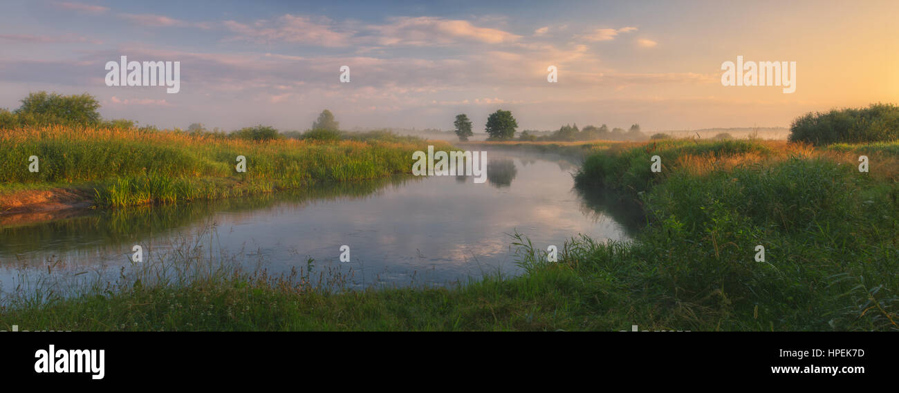 river with clouds of fog in light of morning sun Stock Photo