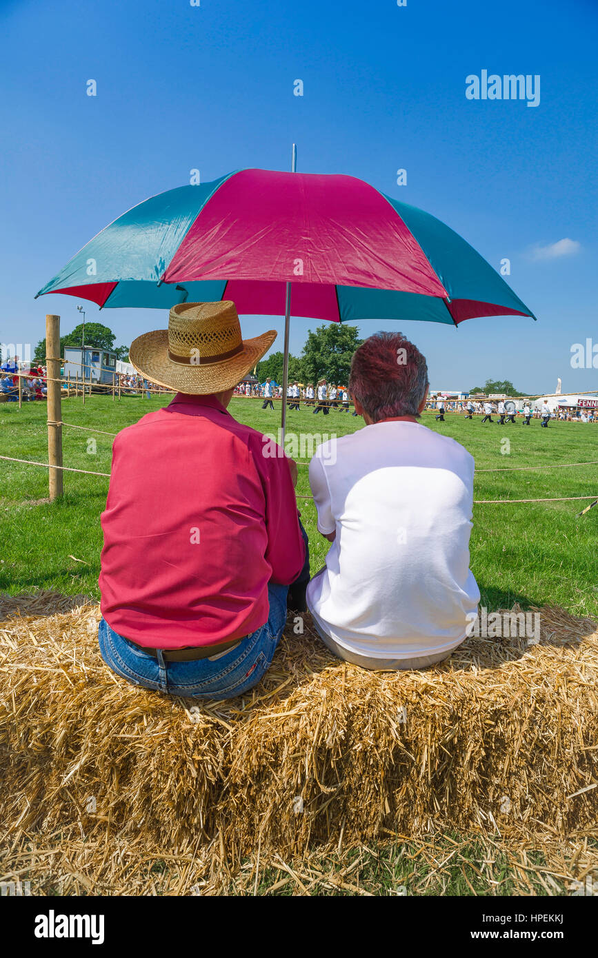 Middle aged couple summer, rear view of a middle-aged couple watching a parade at a country fair in Suffolk, England, UK. Stock Photo