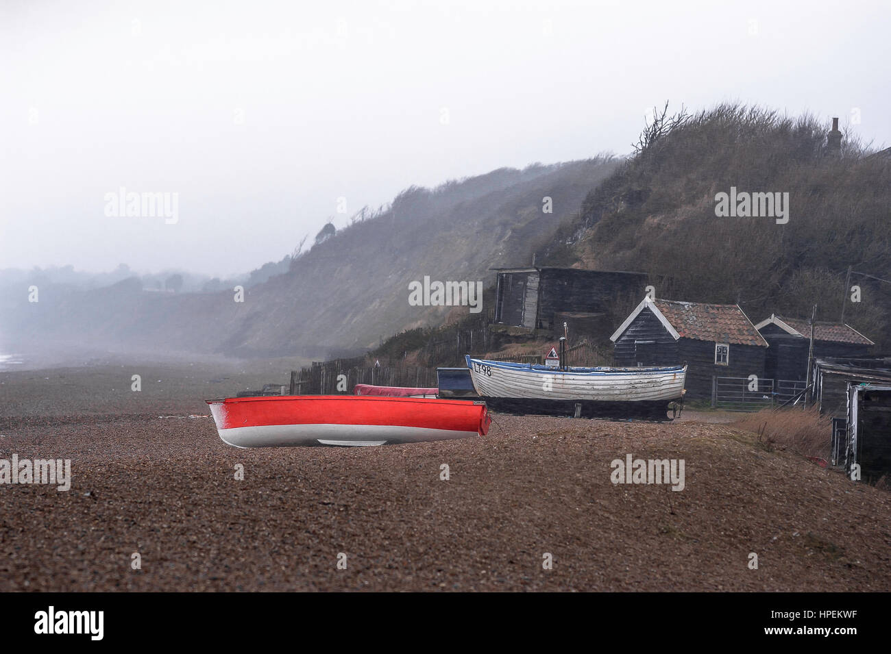 Suffolk winter coast, view of fishing boats and huts in stormy weather