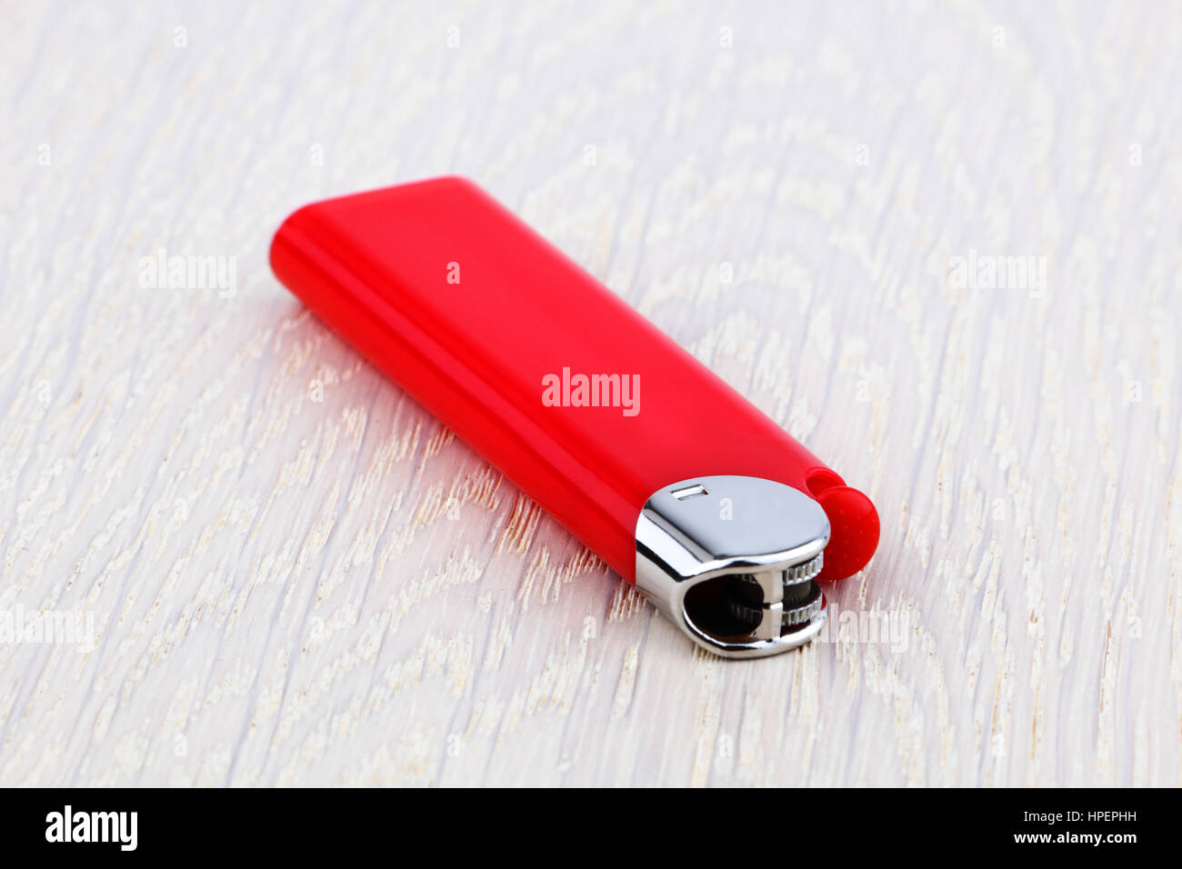 Red lighter on wooden surface Stock Photo