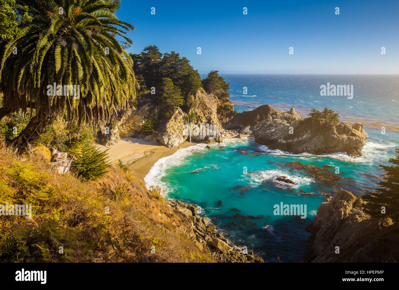 Classic postcard view of famous McWay Falls in golden evening light on a beautiful sunny day, Julia Pfeiffer Burns State Park, Big Sur, California, US Stock Photo