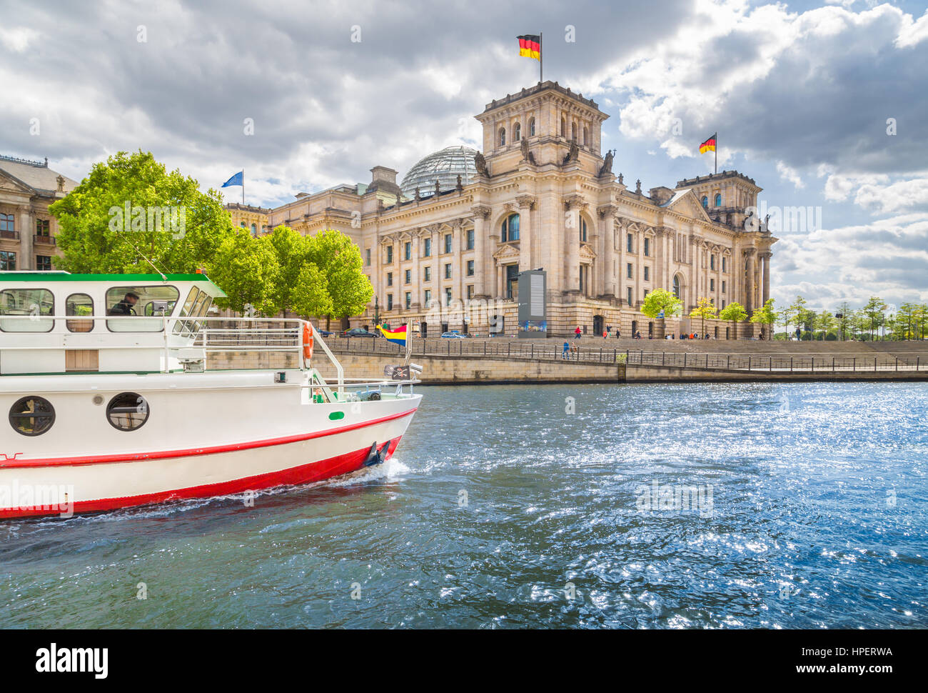 Panoramic view of Berlin government district with excursion boat on Spree river passing famous Reichstag building on a sunny day in summer, Germany Stock Photo