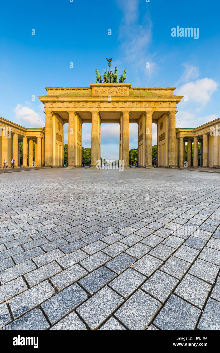 Classic view of famous Brandenburg Gate, one of the best-known landmarks and national symbols of Germany, in beautiful golden morning light at sunrise Stock Photo