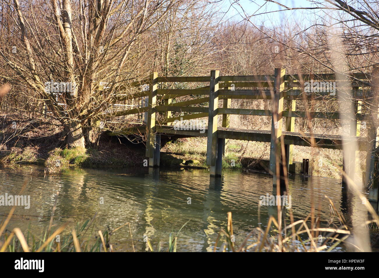 Wooden bridge with reflection in water hires stock photography and