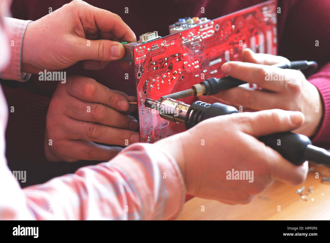 close up of hands two workers soldering motherboard Stock Photo Alamy