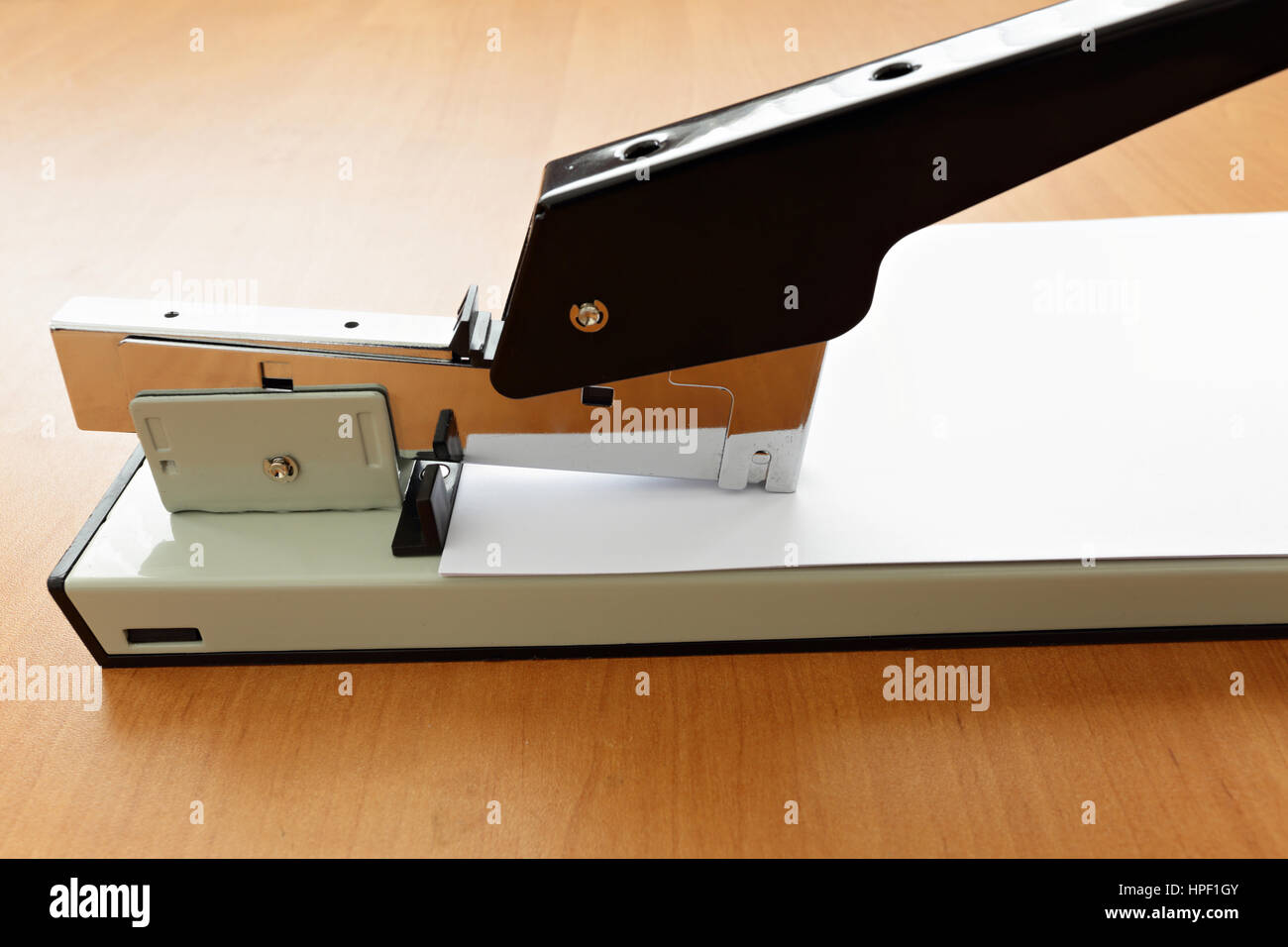 Stapler in work stapling paper on wood table Stock Photo Alamy