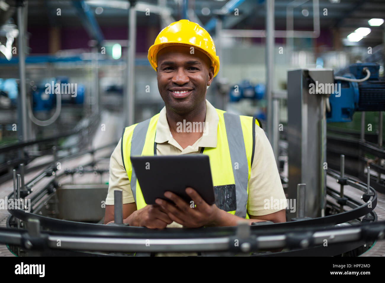 Portrait of smiling factory worker using a digital tablet in the ...