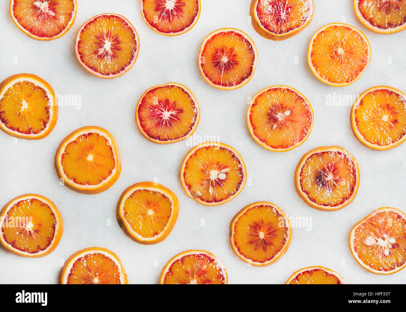 Natural fruit pattern concept. Fresh juicy blood orange slices over light marble table background, top view Stock Photo