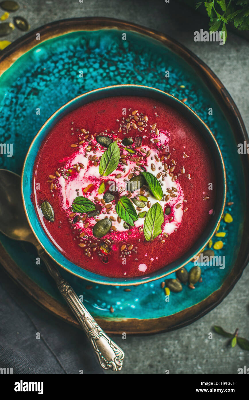 Spring detox beetroot soup with mint, chia, flax and pumpkin seeds in blue ceramic bowl over grey concrete background, top view. Dieting, clean eating Stock Photo