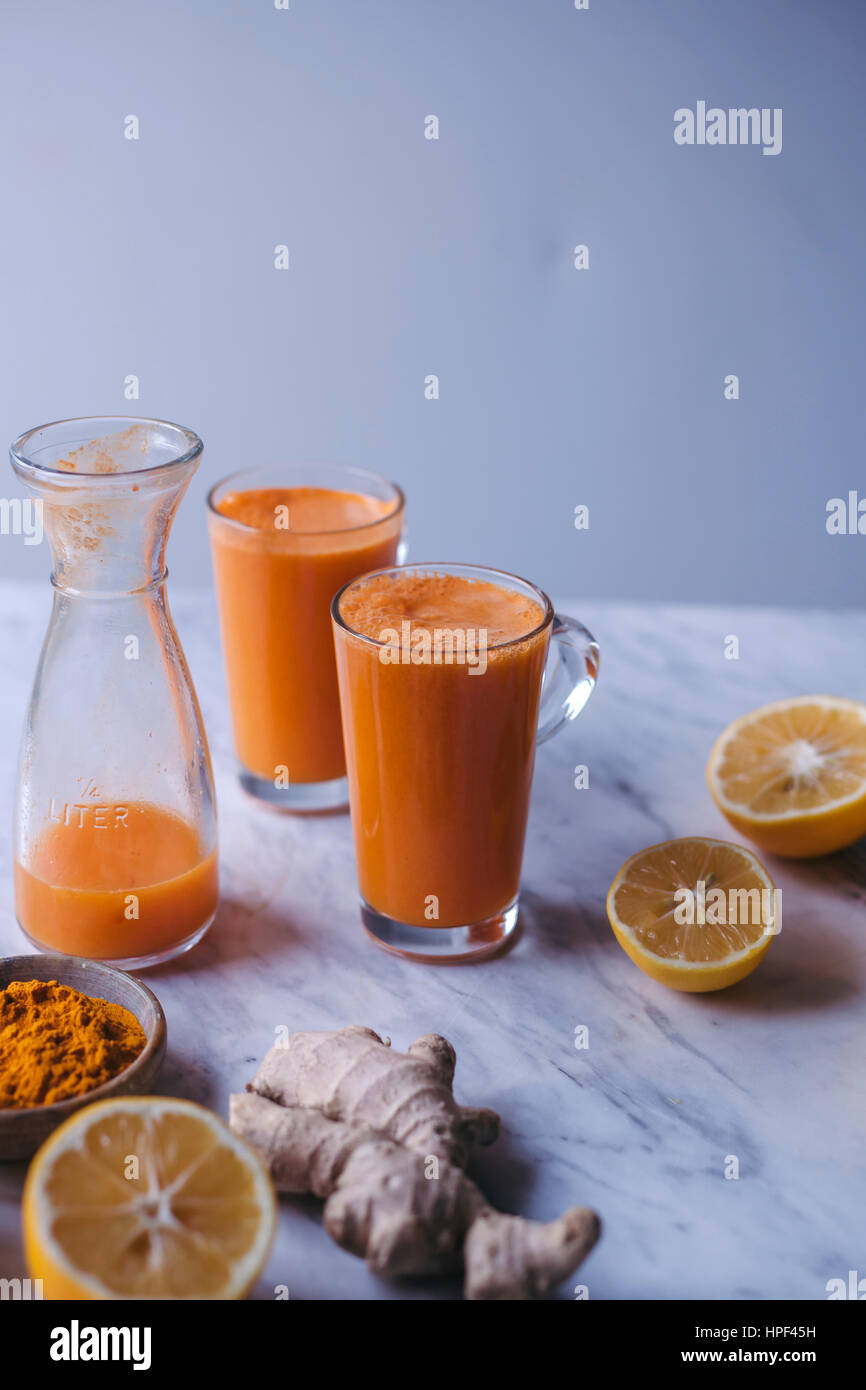 Glasses of orange, lemon and carrot juice with turmeric and ginger Stock Photo