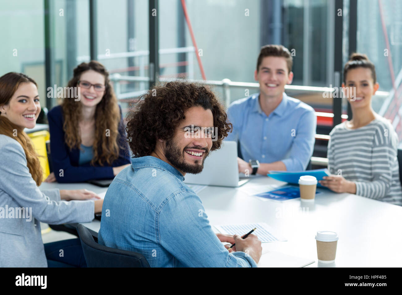 Portrait of smiling business team in a meeting at office Stock Photo ...