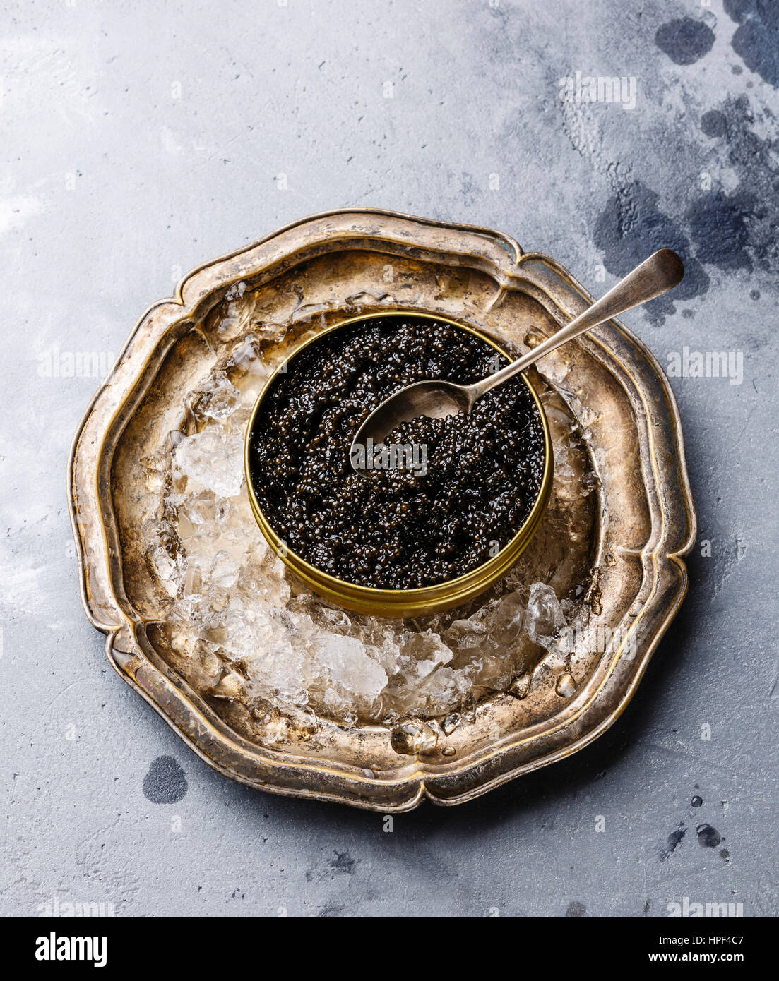 Black Sturgeon caviar in can on ice in metal plate on concrete background copy space Stock Photo