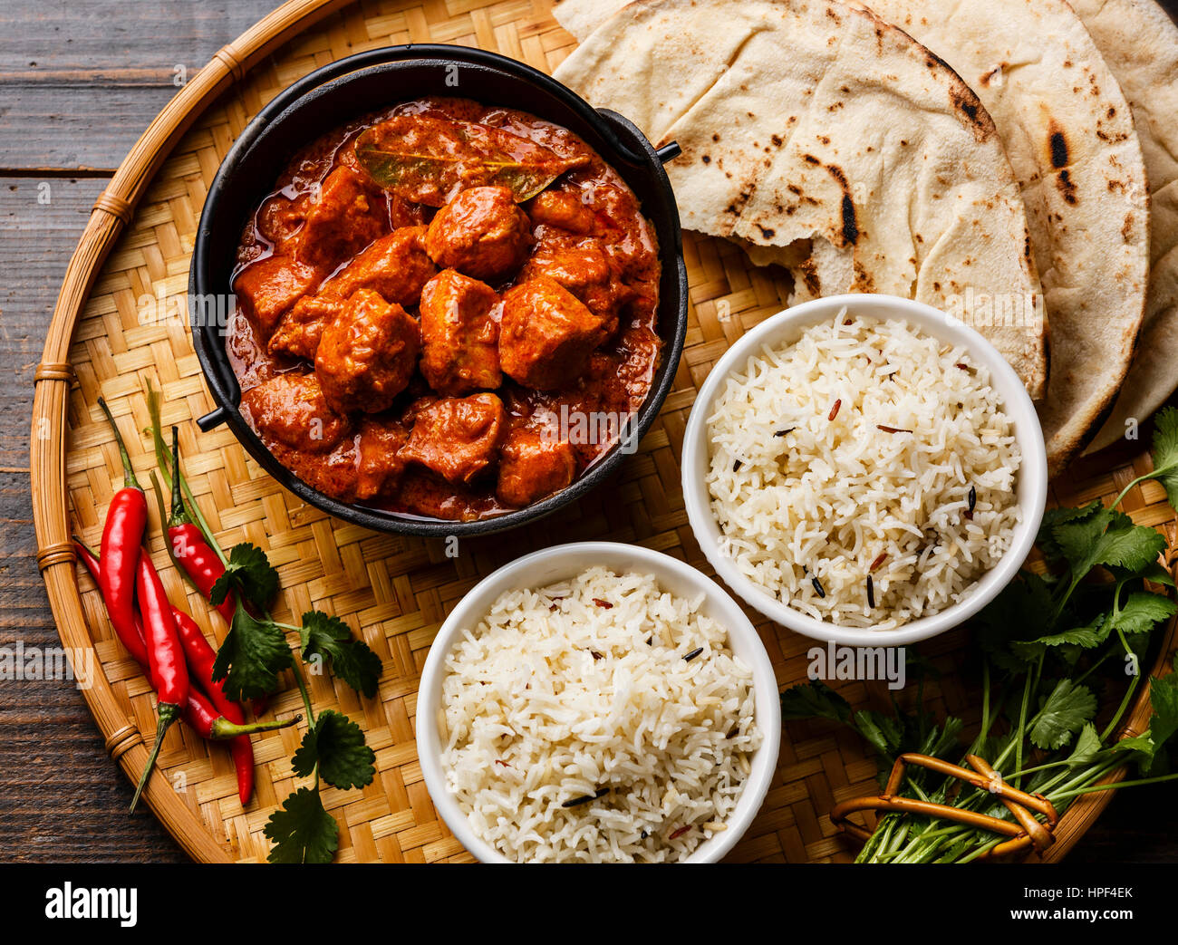 Chicken tikka masala spicy curry meat food in cast iron pot with rice and naan bread close up Stock Photo