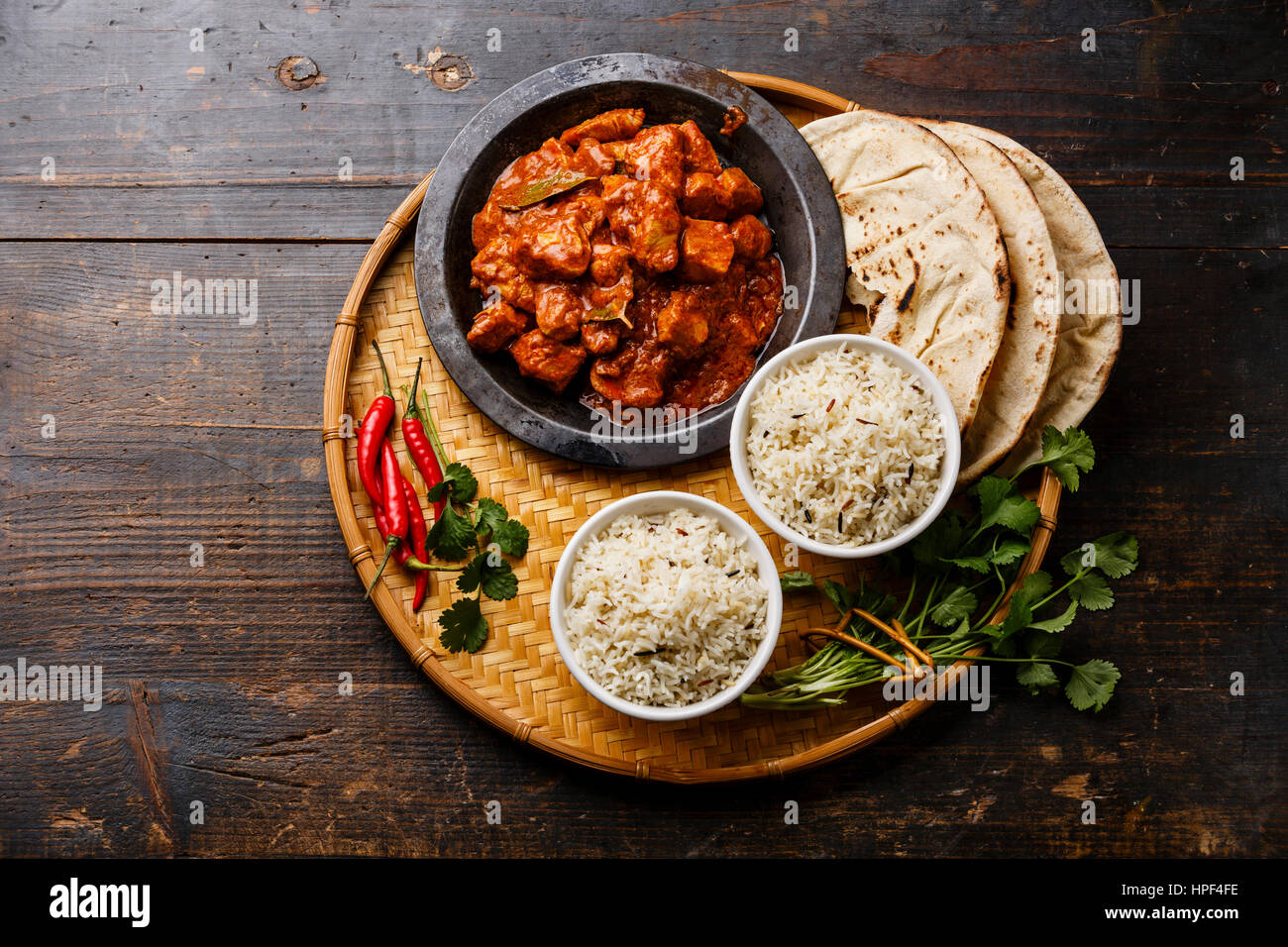 Chicken tikka masala spicy curry meat food with rice and naan bread on wooden background Stock Photo