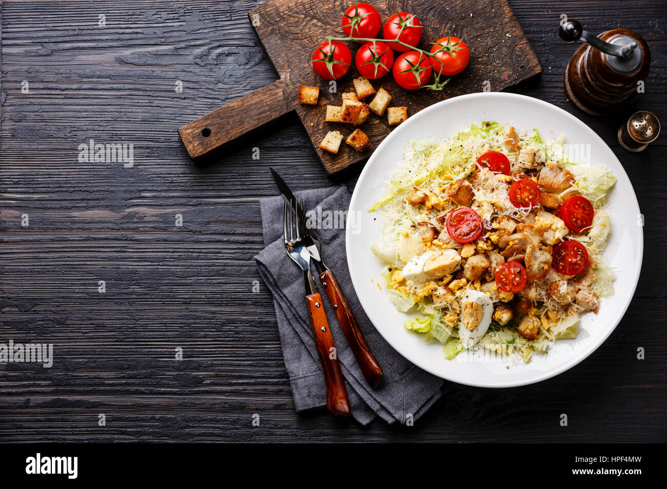 Caesar salad with chicken breast on dark wooden background copy space Stock Photo